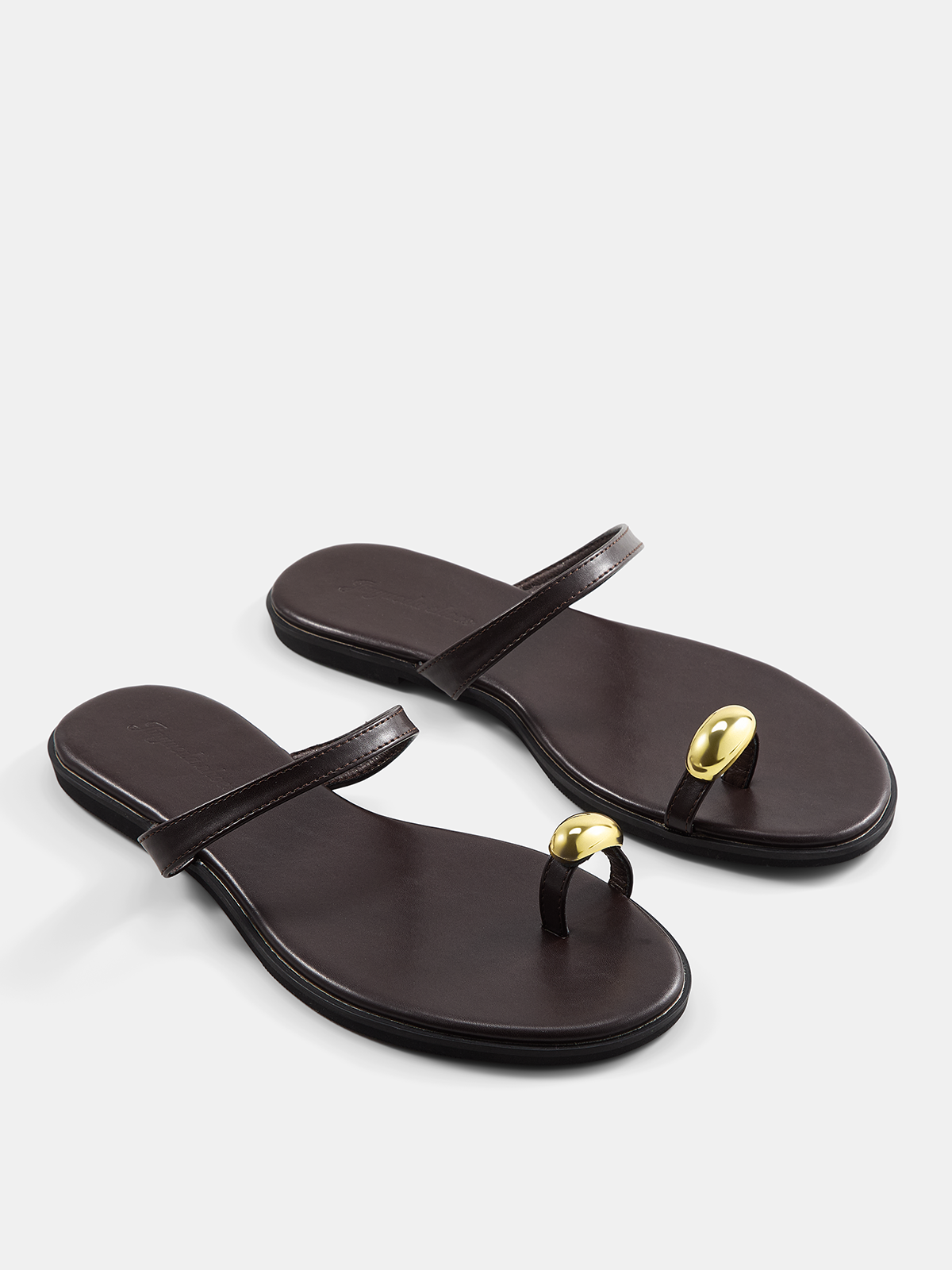 Sandalias planas con tira entre los dedos y detalles metálicos
