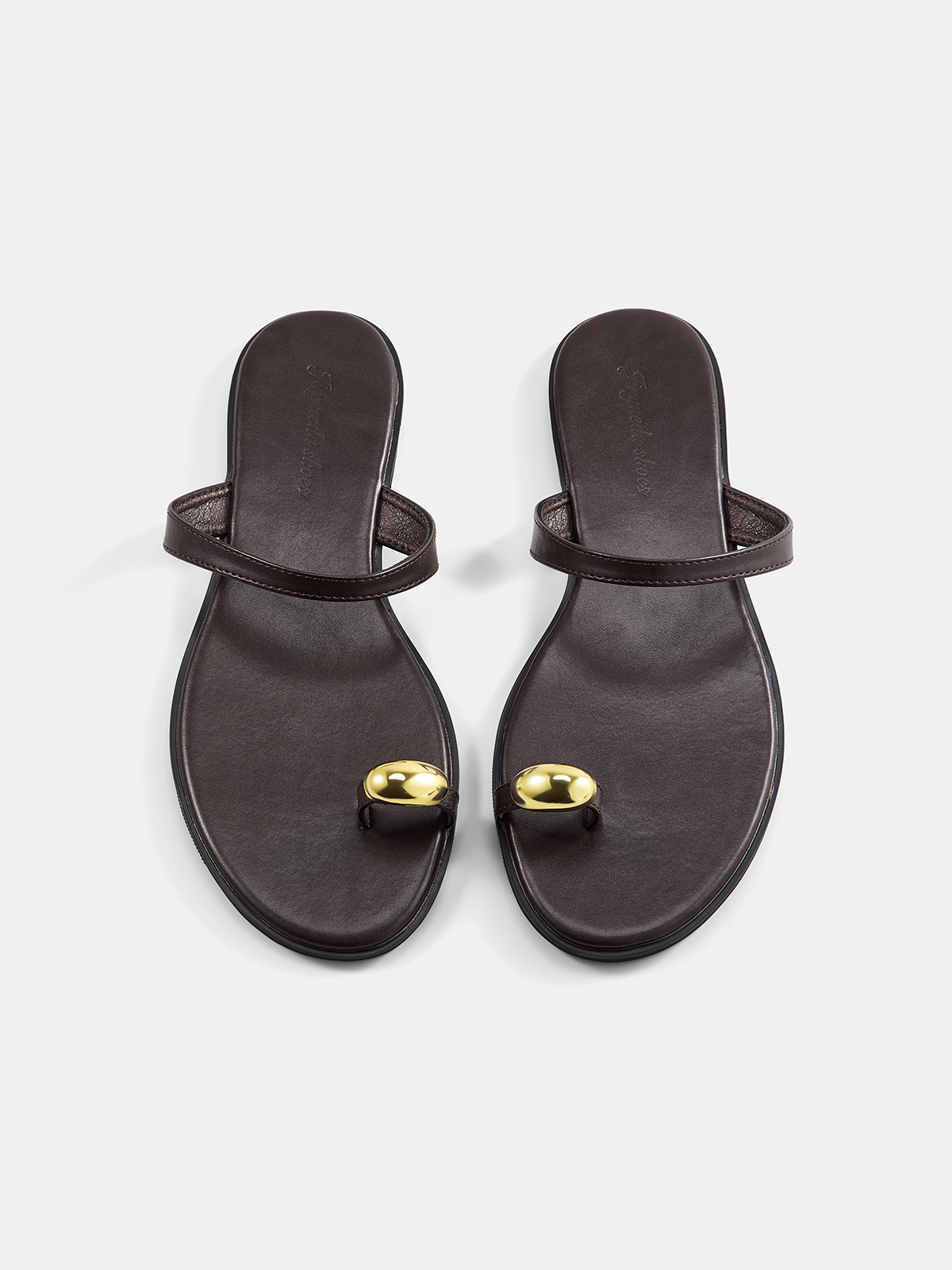Sandalias planas con tira entre los dedos y detalles metálicos